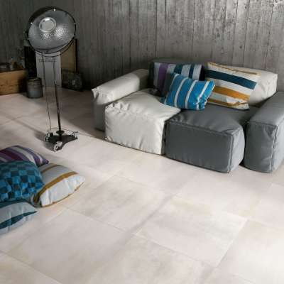 Helle, leicht strukturierte Bodenfliesen im modernen Wohnzimmer mit modularem Sofa.