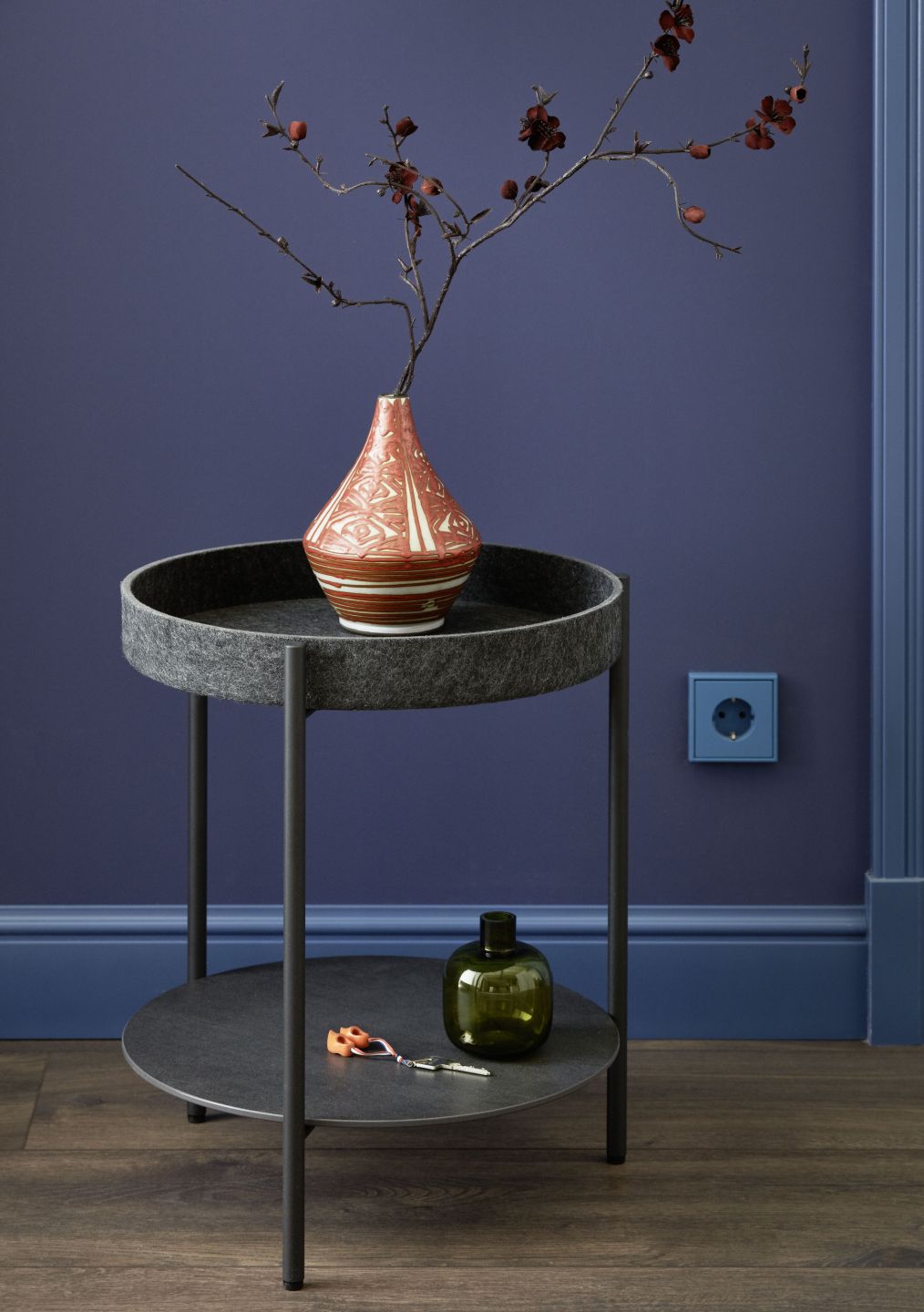 Dunkle Holzoptik-Bodenfliesen und blaue Wand in modernem Interieur.