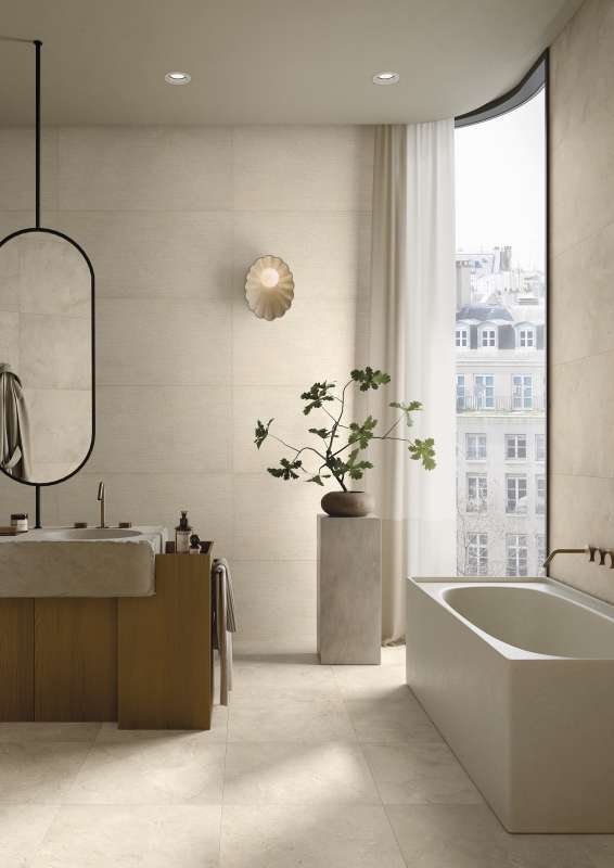 Helles, modernes Badezimmer mit beigefarbenen Wand- und Bodenfliesen.