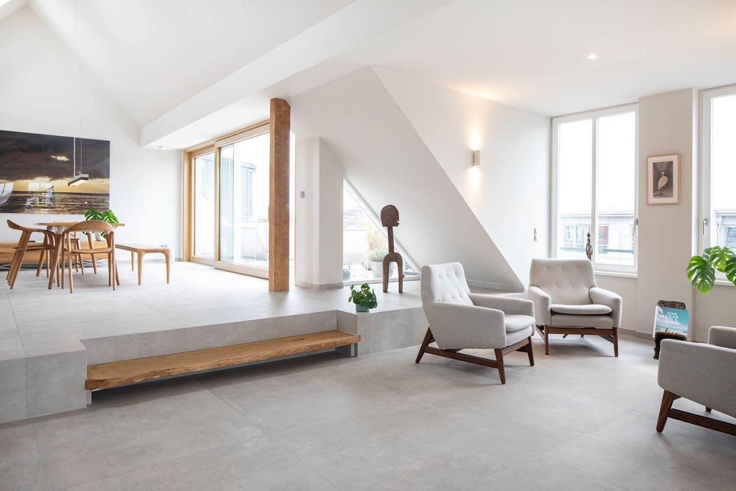 Heller, offener Wohnraum mit modernen grauen Bodenfliesen in Betonoptik.