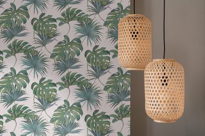 Detailaufnahme: Grün gemusterte Wand und zwei helle Holz-Deko-Elemente.